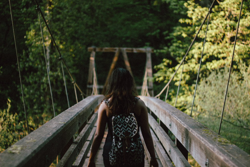 woman crossing a bridge